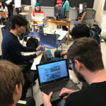 Photo of several students around a table working games.